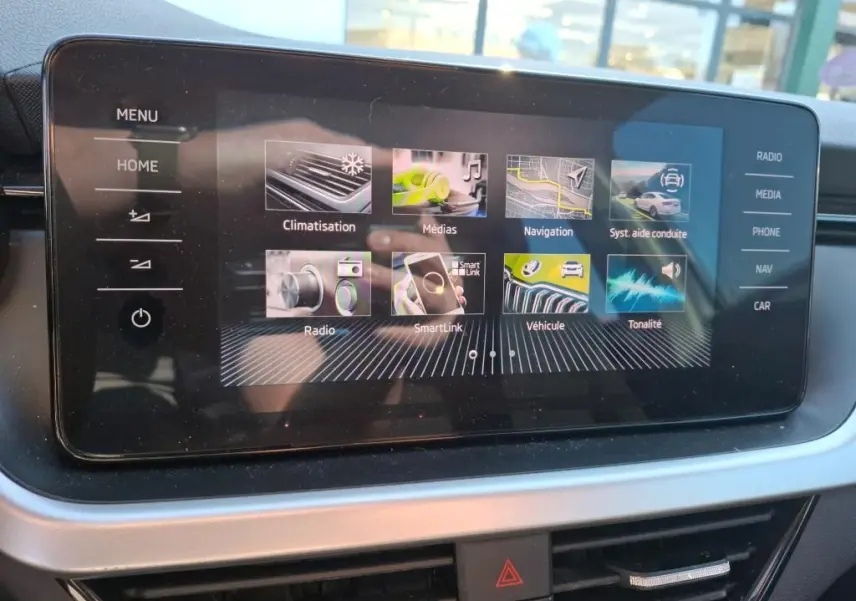 Écran tactile central du Skoda Kamiq 2023 affichant les menus de climatisation, navigation et médias, intérieur noir.