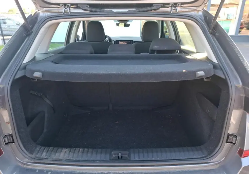 Coffre ouvert vu de l'arrière d'un Skoda Kamiq gris foncé 2023, montrant l'espace de chargement et l'intérieur noir.