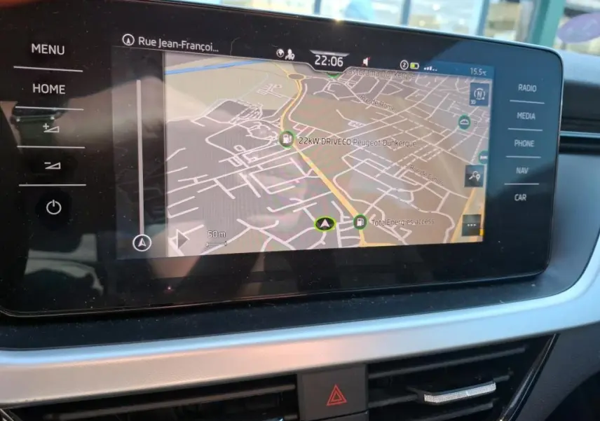 Écran tactile central du Skoda Kamiq 2023 affichant la navigation GPS avec commandes tactiles sur les côtés.