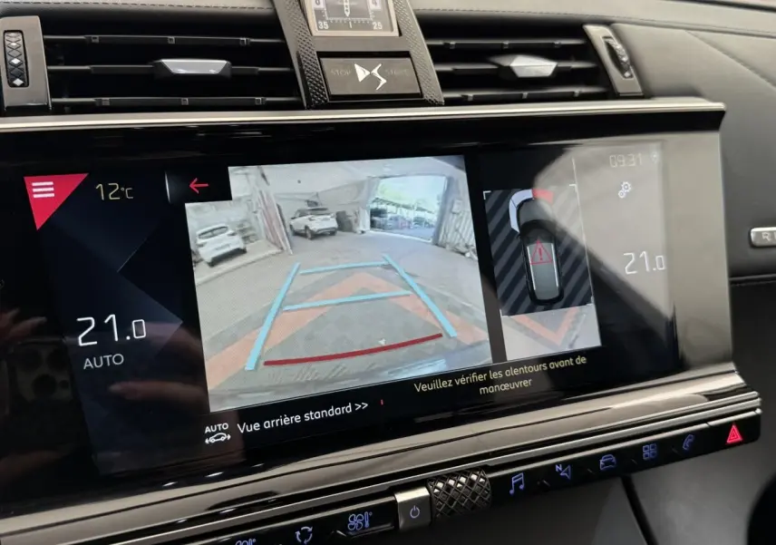 Écran tactile central du DS7 Crossback gris foncé montrant la caméra de recul et l'aide au stationnement.