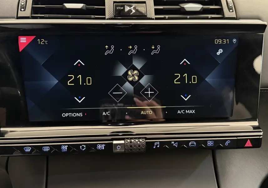 Gros plan sur l’écran tactile central du DS7 Crossback gris foncé, affichant la climatisation à 21°C en mode automatique.