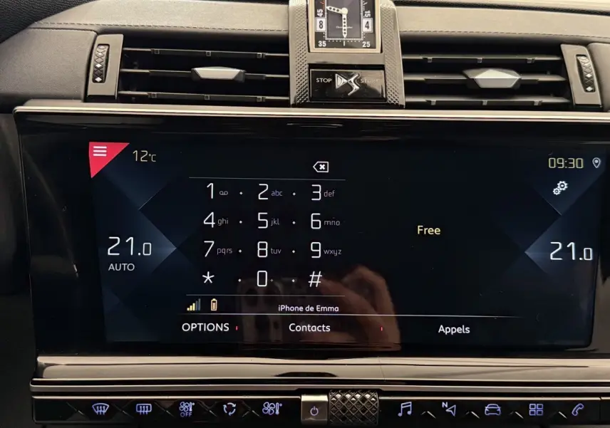 Vue rapprochée de l’écran tactile central du DS7 Crossback gris foncé, affichant le clavier téléphonique et la température à 21°C.