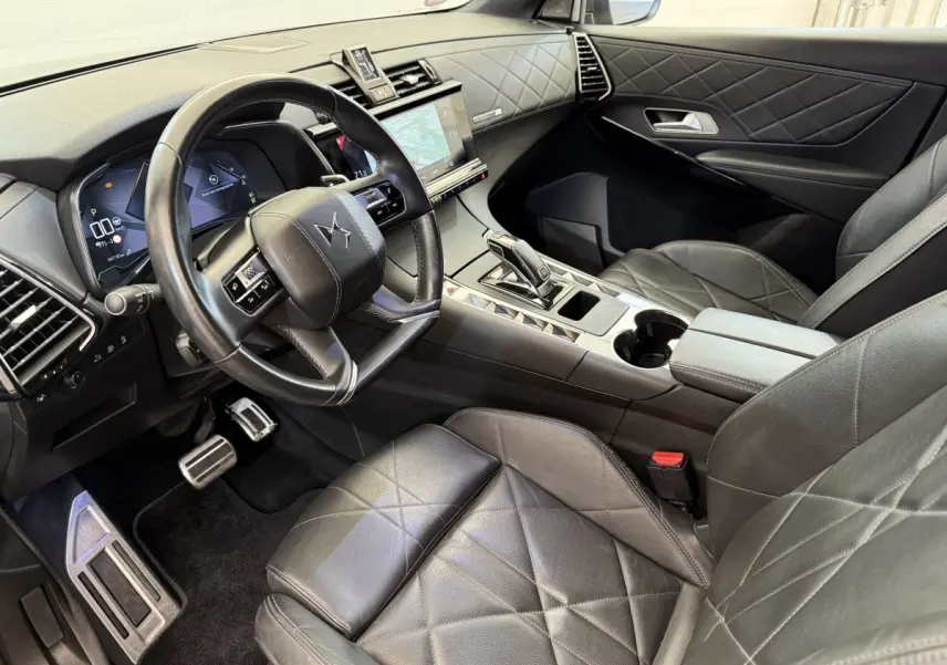 Intérieur DS7 Crossback vu côté conducteur, cuir noir matelassé et tableau de bord avec écran tactile central.