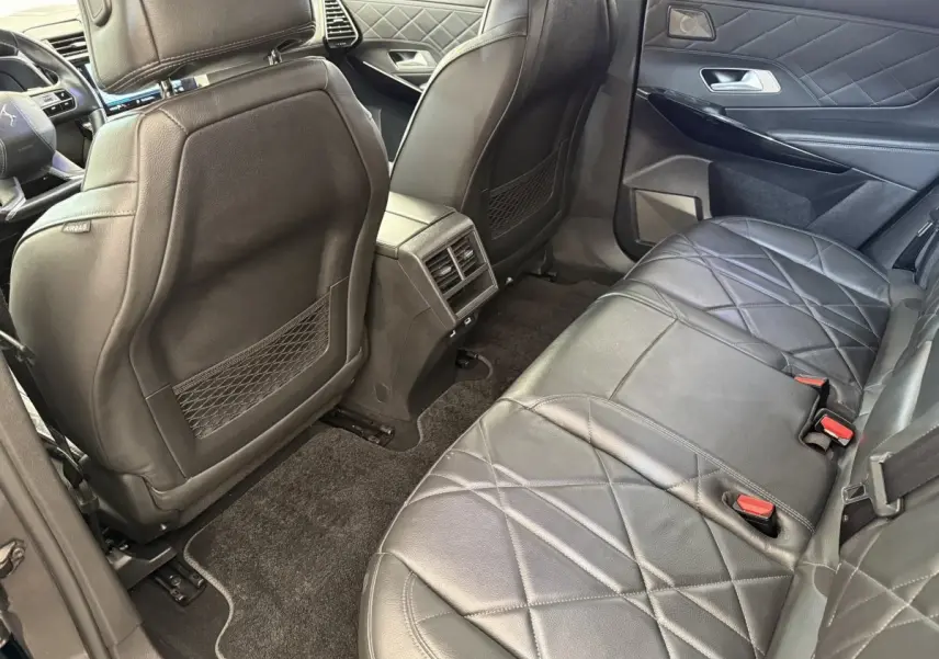 Vue intérieure arrière côté droit du DS7 Crossback avec sièges en cuir noir matelassé et finitions élégantes.