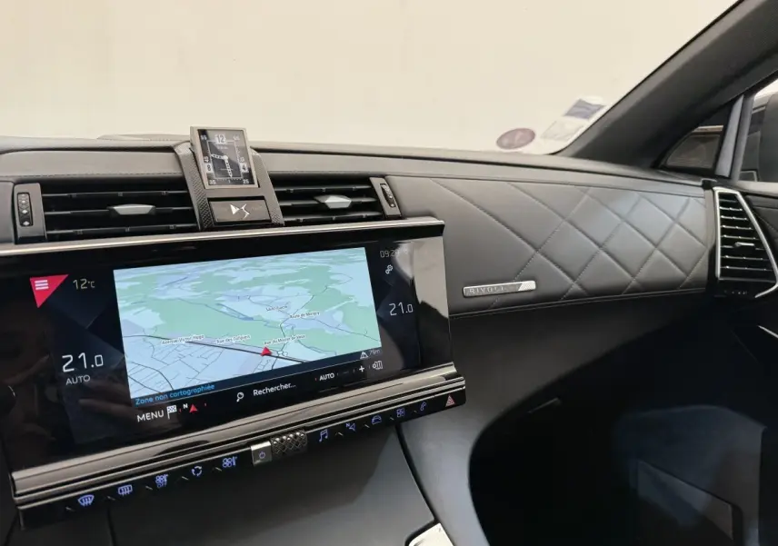 Vue intérieure côté passager du tableau de bord noir matelassé avec écran tactile de navigation et horloge DS7 Crossback.