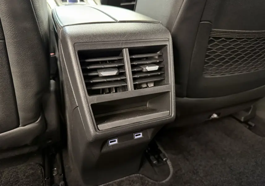 Vue rapprochée des aérateurs arrière et ports USB du DS7 Crossback gris foncé, intérieur cuir noir.