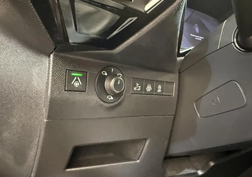 Gros plan sur les commandes noires du tableau de bord côté gauche du DS7 Crossback gris foncé, avec bouton d'aide à la conduite activé.