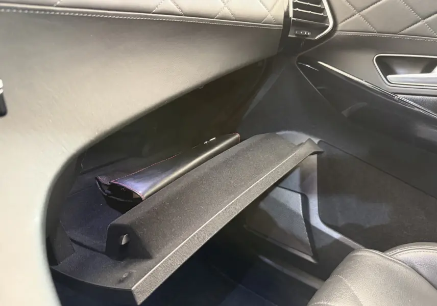 Vue intérieure côté passager du coffre à gants ouvert en cuir noir matelassé du DS7 Crossback gris foncé 2018.