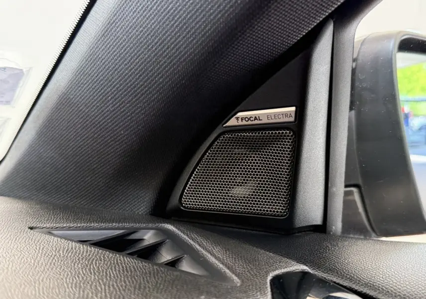 Gros plan sur haut-parleur Focal Electra côté gauche dans l’habitacle du DS7 Crossback gris foncé, avec rétro extérieur visible.