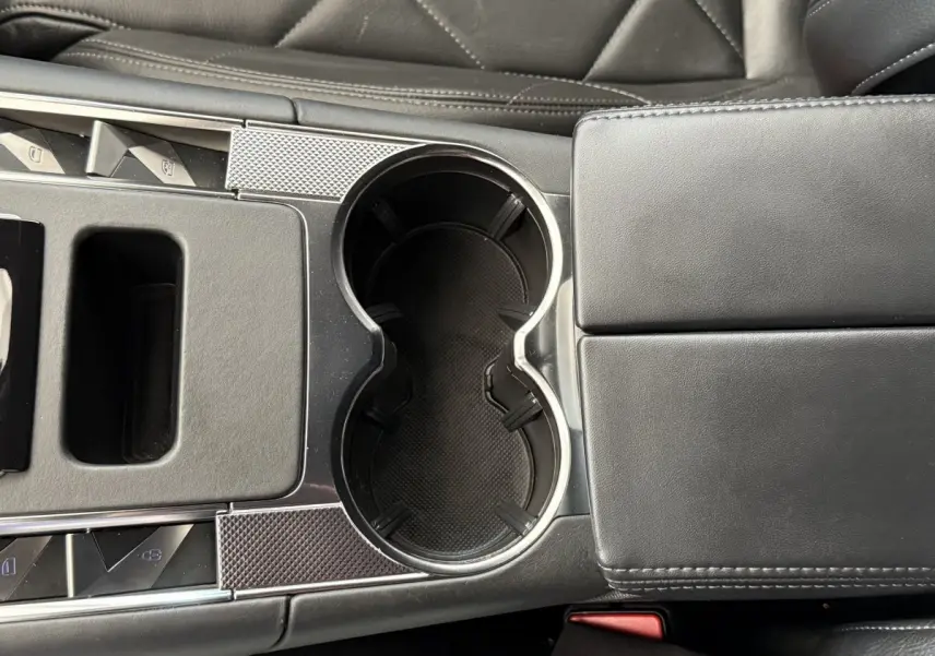 Gros plan sur la console centrale noire du DS7 Crossback 2018, mettant en valeur les porte-gobelets et accoudoir cuir.