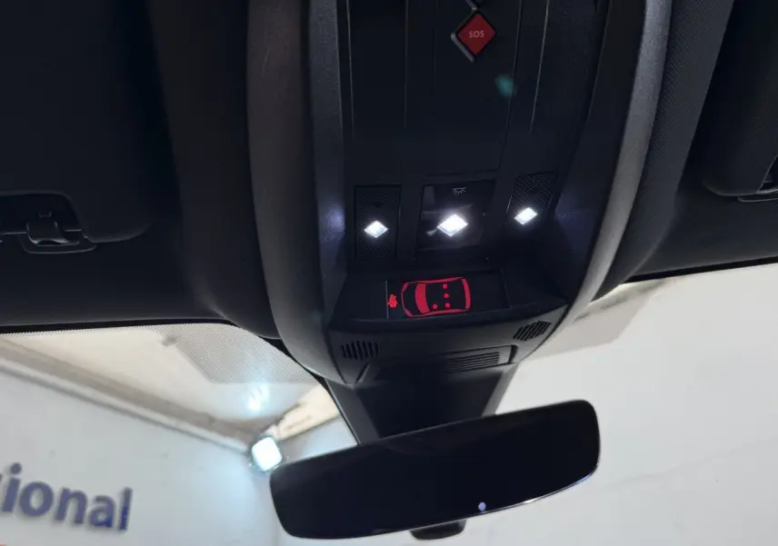 Vue intérieure en contre-plongée du plafonnier avec éclairage et indicateur de porte ouverte du DS7 Crossback gris foncé.