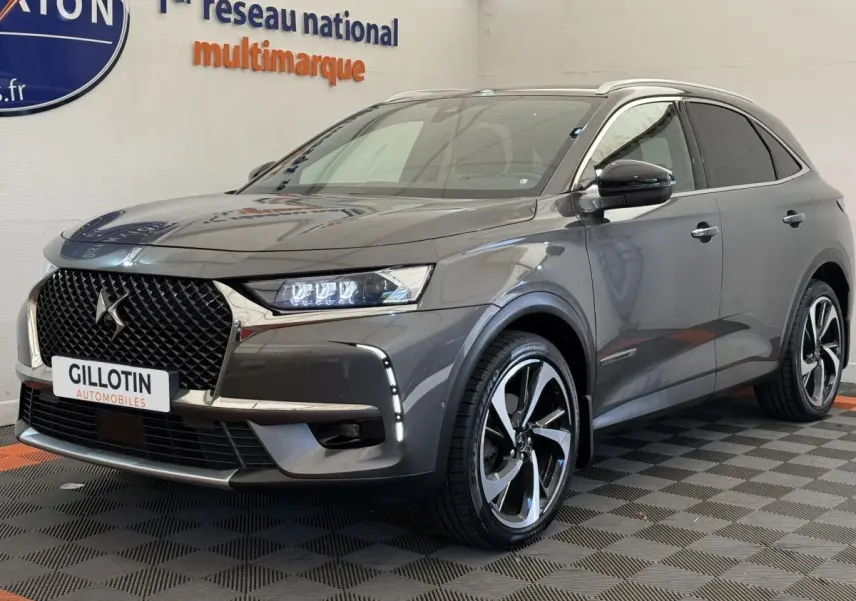 DS7 Crossback gris foncé en 3/4 avant droit, avec calandre distinctive et jantes alliage bicolores.