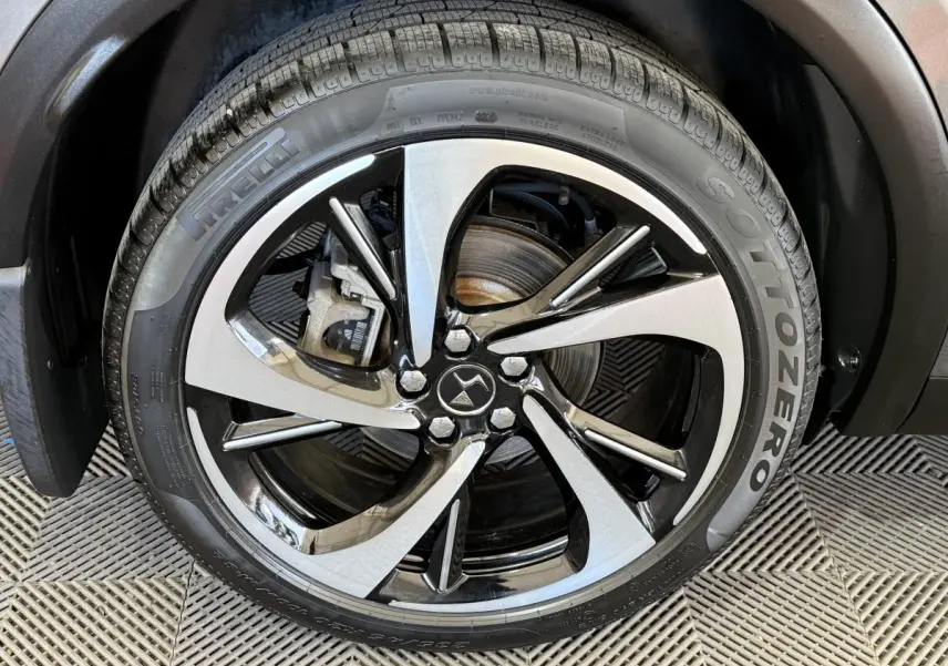 Gros plan sur la roue avant droite du DS7 Crossback gris foncé avec jante alliage bicolore et pneu Pirelli Sottozero.