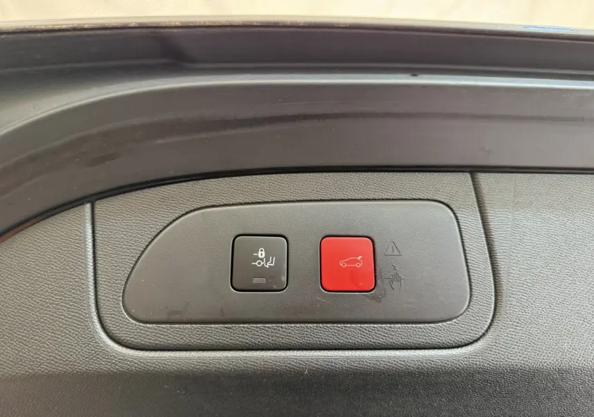 Boutons de commande du coffre électrique sur le bord intérieur d’un DS7 Crossback gris foncé, vue rapprochée.