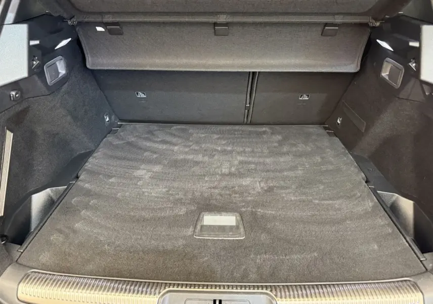Vue intérieure du coffre spacieux gris foncé du DS7 Crossback PureTech 180 Grand Chic, avec cache-bagages déployé.