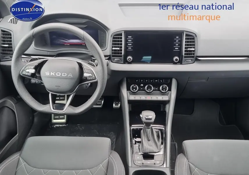 Vue intérieure frontale du tableau de bord et volant cuir noir du Skoda Karoq 1.5 TSI Sportline 2025.