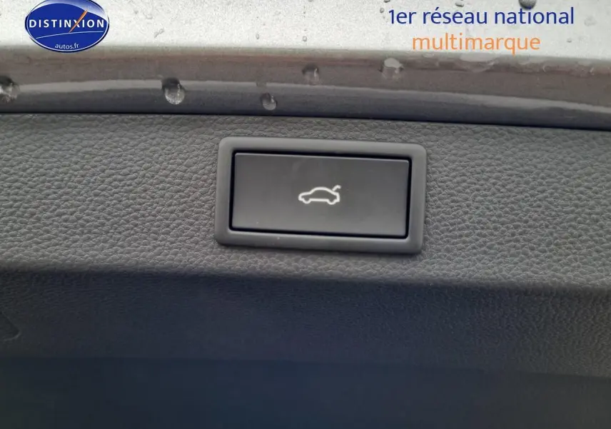 Bouton d'ouverture de coffre noir sur tableau de bord intérieur du Skoda Karoq gris graphite 2025.