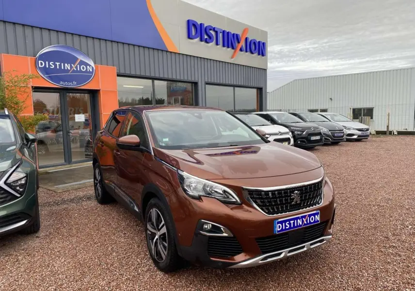 Peugeot 3008 marron foncé vue 3/4 avant avec jantes alliage, stationnée devant un garage Distinxion.