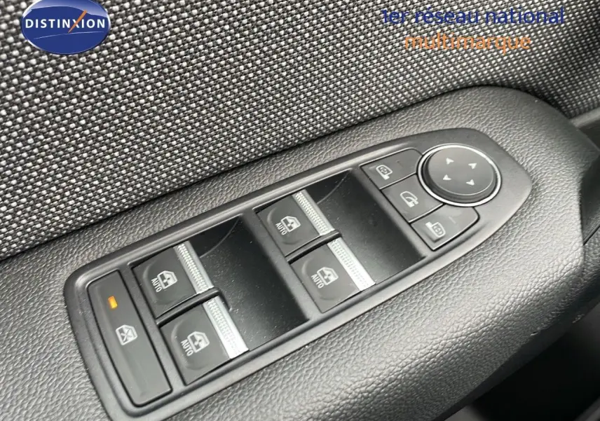 Gros plan sur les commandes de lève-vitres et rétroviseurs du côté conducteur du Renault Captur gris Rafale 2025.