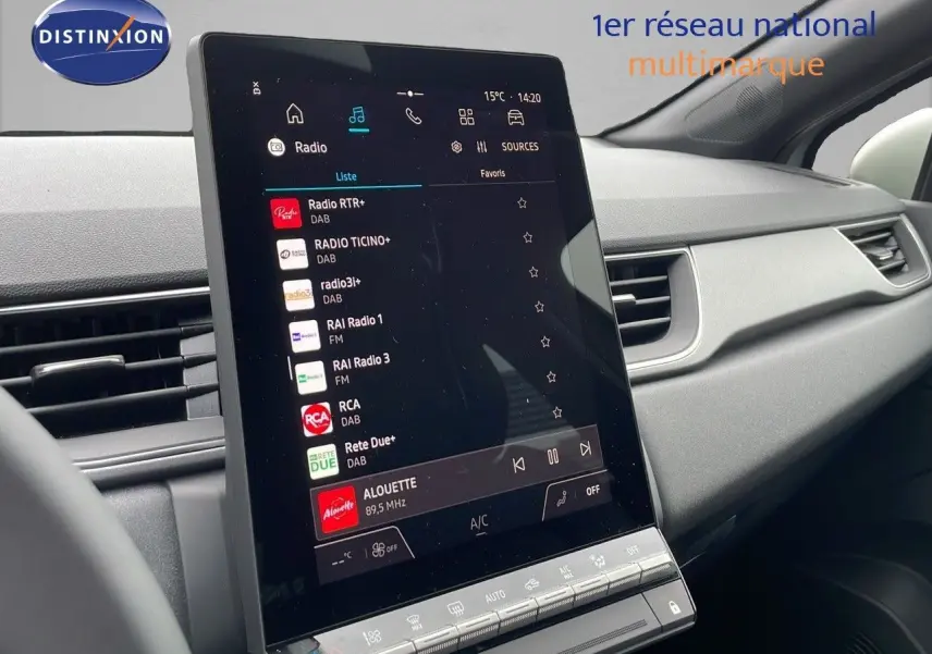 Vue intérieure du tableau de bord du Renault Captur 2025, écran tactile central affichant les stations radio, ambiance moderne gris clair.