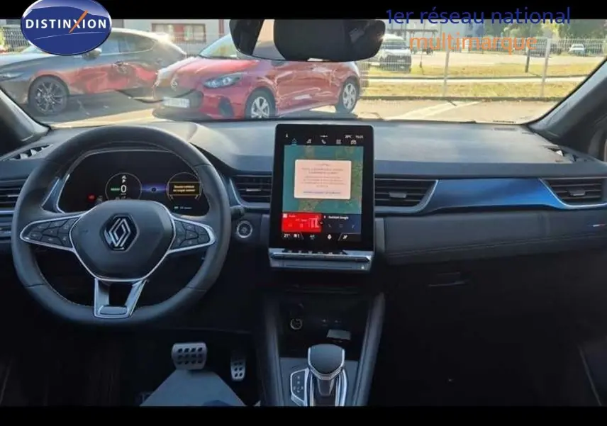Intérieur avant du Renault Captur E-Tech hybride 2025, tableau de bord noir avec écran tactile vertical central.