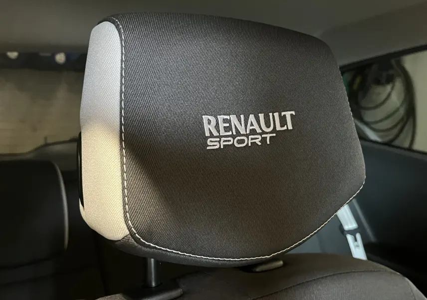 Gros plan sur l'appui-tête avant noir avec logo Renault Sport brodé, intérieur de Renault Clio III RS 20th Anniversary.