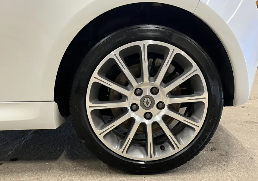 Gros plan sur la roue arrière droite de la Renault Clio III RS 20th Anniversary blanc nacré avec jante alliage 17 pouces.