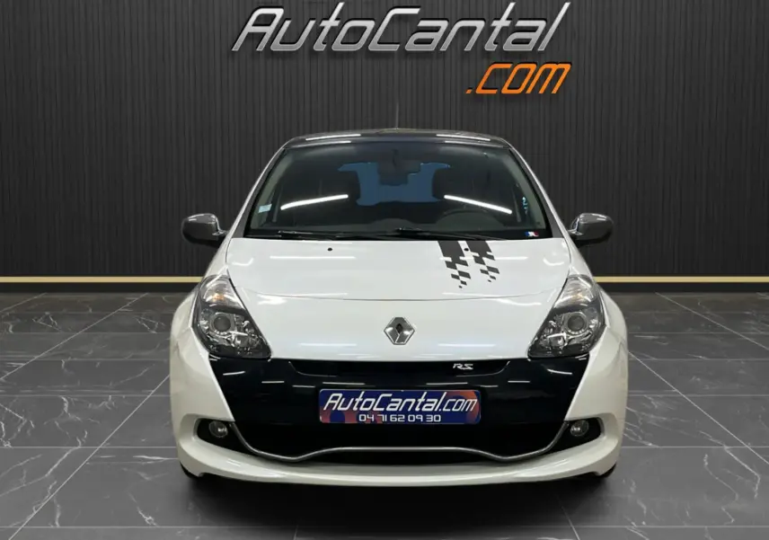 Vue frontale d'une Renault Clio III RS 20th Anniversary blanc nacré avec toit noir et bandeau décoratif sur le capot.