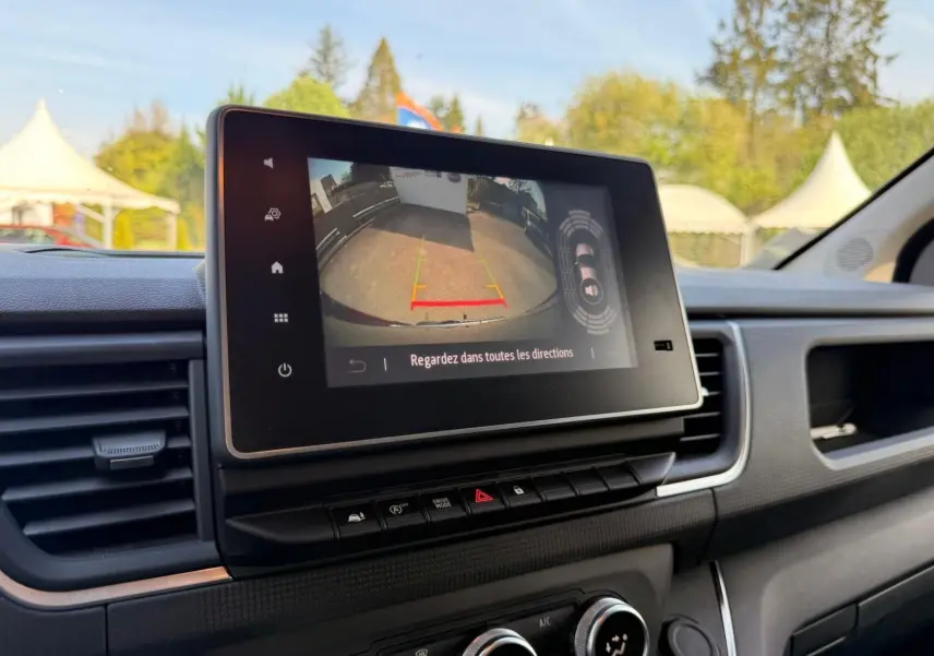 Vue rapprochée de l’écran tactile intérieur du Renault Trafic gris comète, affichant la caméra de recul avec guidage.