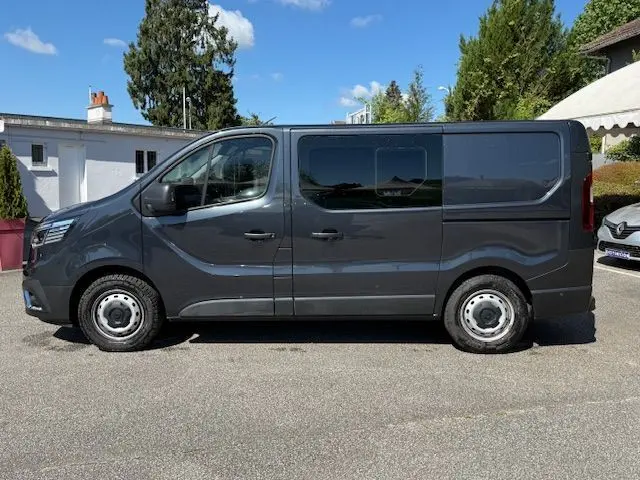 Vue de profil côté gauche d’un Renault Trafic Cabine Approfondie gris comète avec portes latérales vitrées.
