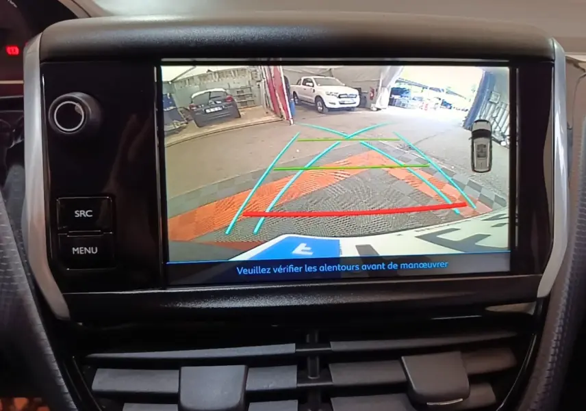 Écran tactile intérieur montrant la caméra de recul d'une Peugeot 2008 noire, vue arrière avec guidage de trajectoire.