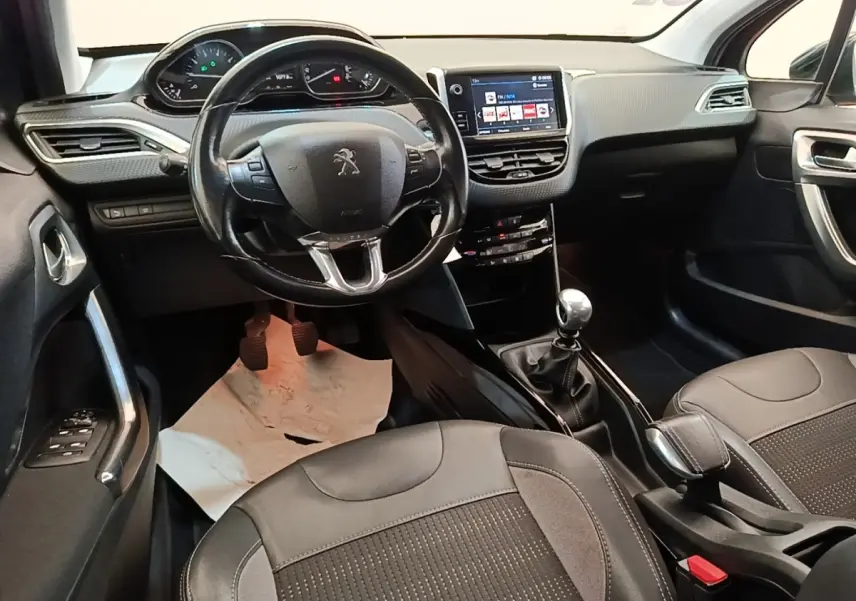 Vue intérieure avant du Peugeot 2008 avec volant cuir, tableau de bord digital et écran tactile central.