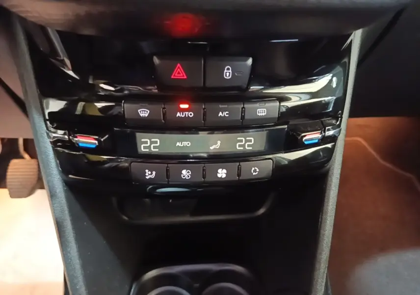 Vue rapprochée de la console centrale noire du Peugeot 2008 2019, avec commandes climatisation digitale affichant 22°C.