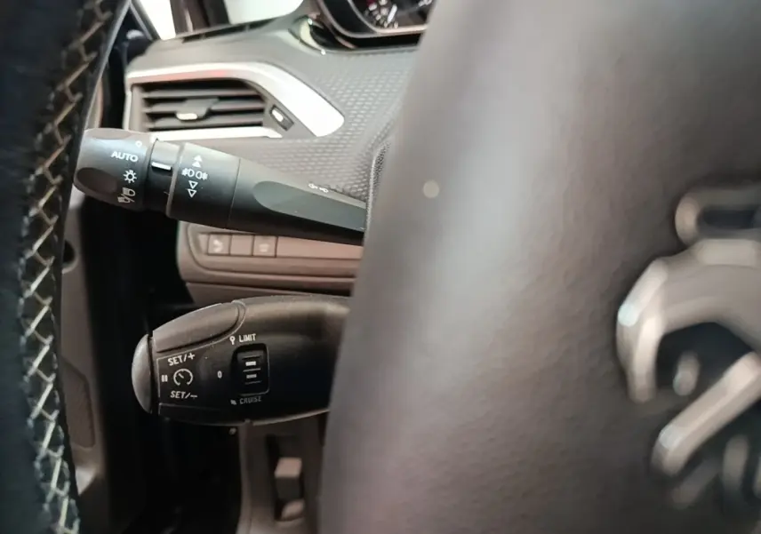 Gros plan sur le volant cuir noir et les commandes de régulateur de vitesse de la Peugeot 2008 Puretech 2019.