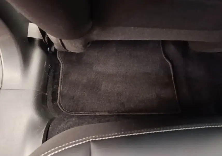 Vue rapprochée du tapis de sol noir et de la moquette sous le siège arrière côté droit d’un Peugeot 2008 noir.