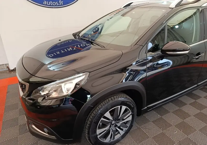 Vue 3/4 avant droit d’un Peugeot 2008 noir avec jantes alliage et rétroviseurs noirs brillants.