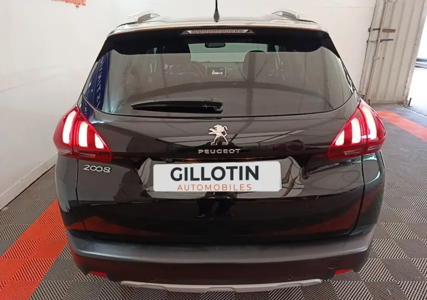Vue arrière d’un Peugeot 2008 noir avec feux LED allumés dans un garage intérieur.