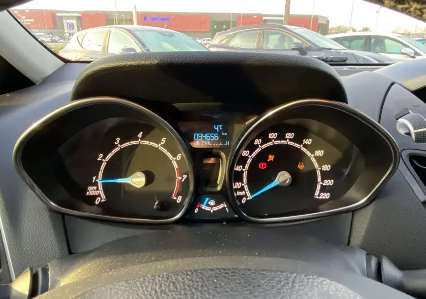 Vue intérieure du tableau de bord de la Ford B-MAX blanche de 2014, affichant le compteur et le compte-tours.