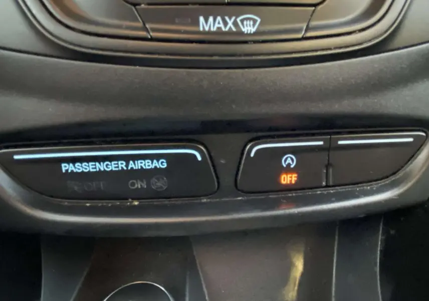 Gros plan sur les commandes du tableau de bord du Ford B-MAX blanc, affichant l'airbag passager et le système Stop & Start désactivé.