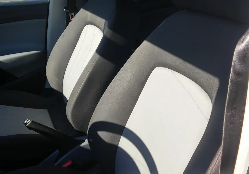 Gros plan sur les sièges avant gris clair et foncé de la SEAT Ibiza Business blanche, version diesel 2015.