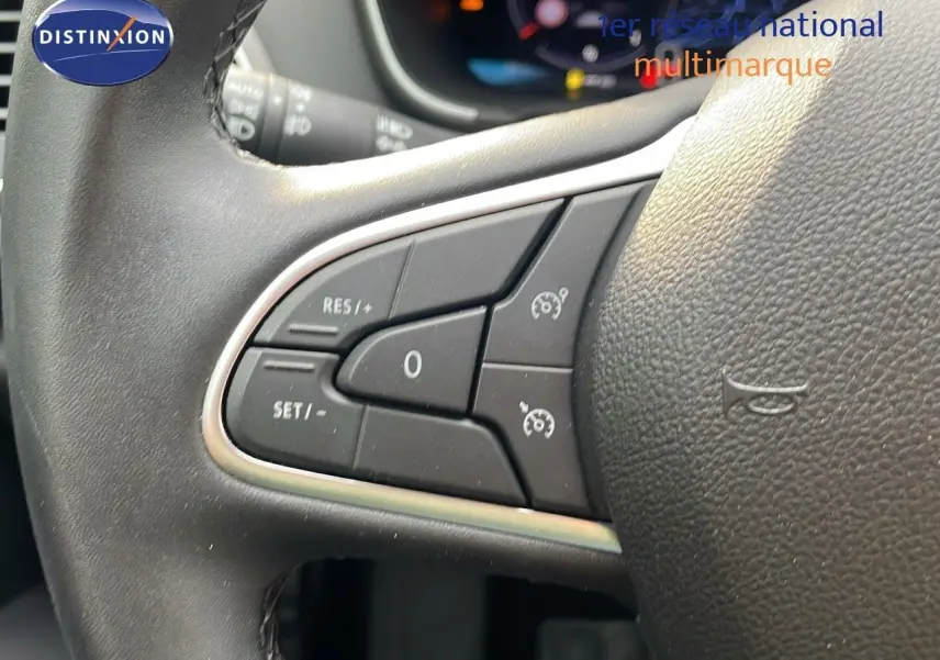 Gros plan sur les commandes de régulateur de vitesse au volant cuir noir d'une Renault Mégane Break gris Highland Metal 2024