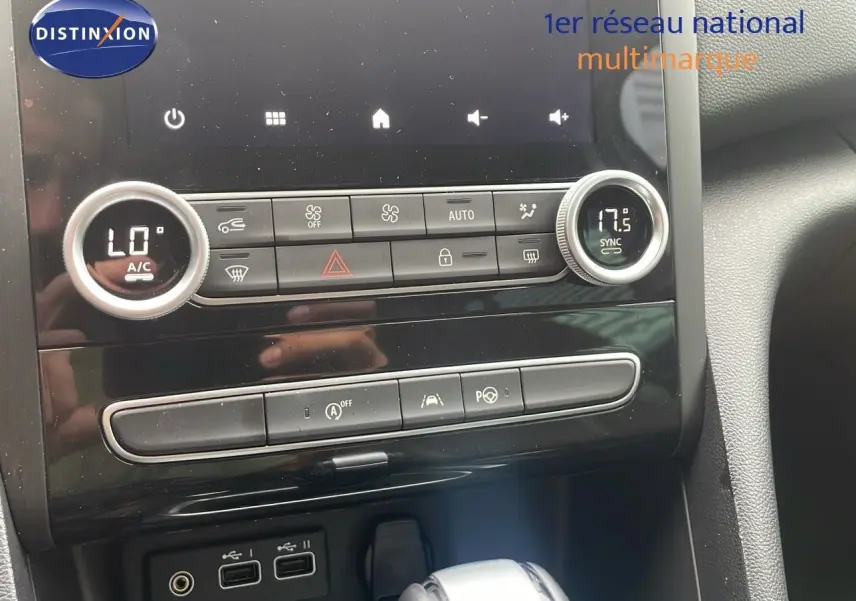 Vue rapprochée de la console centrale de la Renault Mégane Break 2024 gris Highland Metal, montrant les commandes climatisation et la boîte auto.