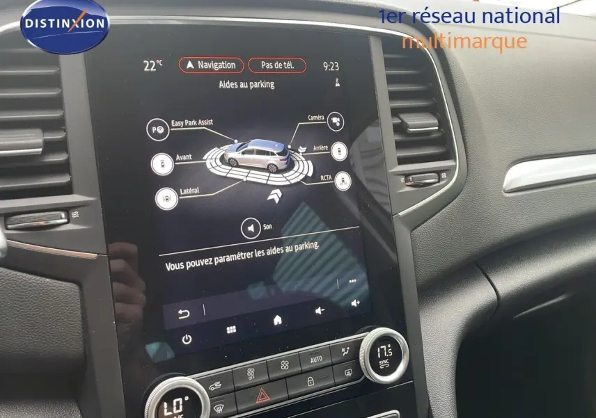 Écran tactile central affichant l'aide au parking de la Renault Mégane Break gris Highland Metal, intérieur noir moderne.