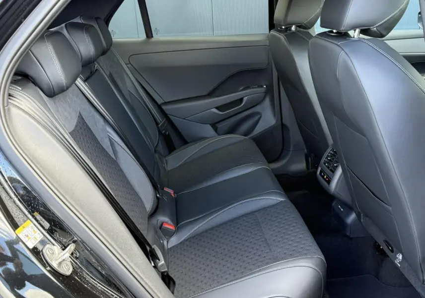 Vue côté gauche de l'intérieur arrière du Volkswagen T-Roc noir Ébène, avec sièges en tissu et cuir R-Line.