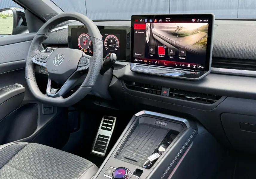 Vue intérieure côté conducteur du Volkswagen T-Roc 2026, avec volant cuir, écran tactile et sellerie tissu R-Line grise.