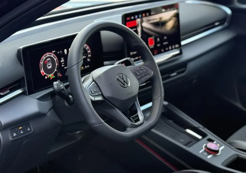Vue intérieure du tableau de bord et volant noir du Volkswagen T-Roc 1.5 eTSI Hybrid avec écran digital et console centrale moderne.