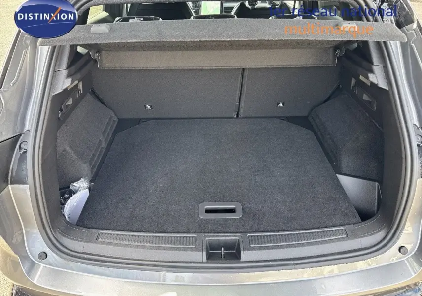 Coffre ouvert vu de l'arrière d'un Renault Austral gris schiste métal avec toit noir, montrant un espace de chargement propre et spacieux.