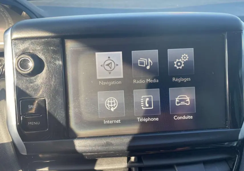 Écran tactile central de la Peugeot 208 noire de 2016 affichant les menus navigation, radio, réglages, internet, téléphone et conduite.