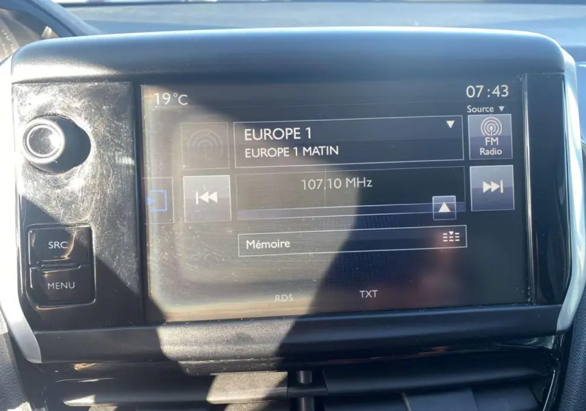 Écran tactile 7 pouces du système de navigation Peugeot 208 noir 2016 affichant la radio Europe 1 à 07:43