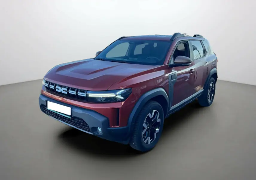 Dacia Duster 2024 brun terracotta en 3/4 avant droit, avec calandre noire et protections grises sur les ailes.